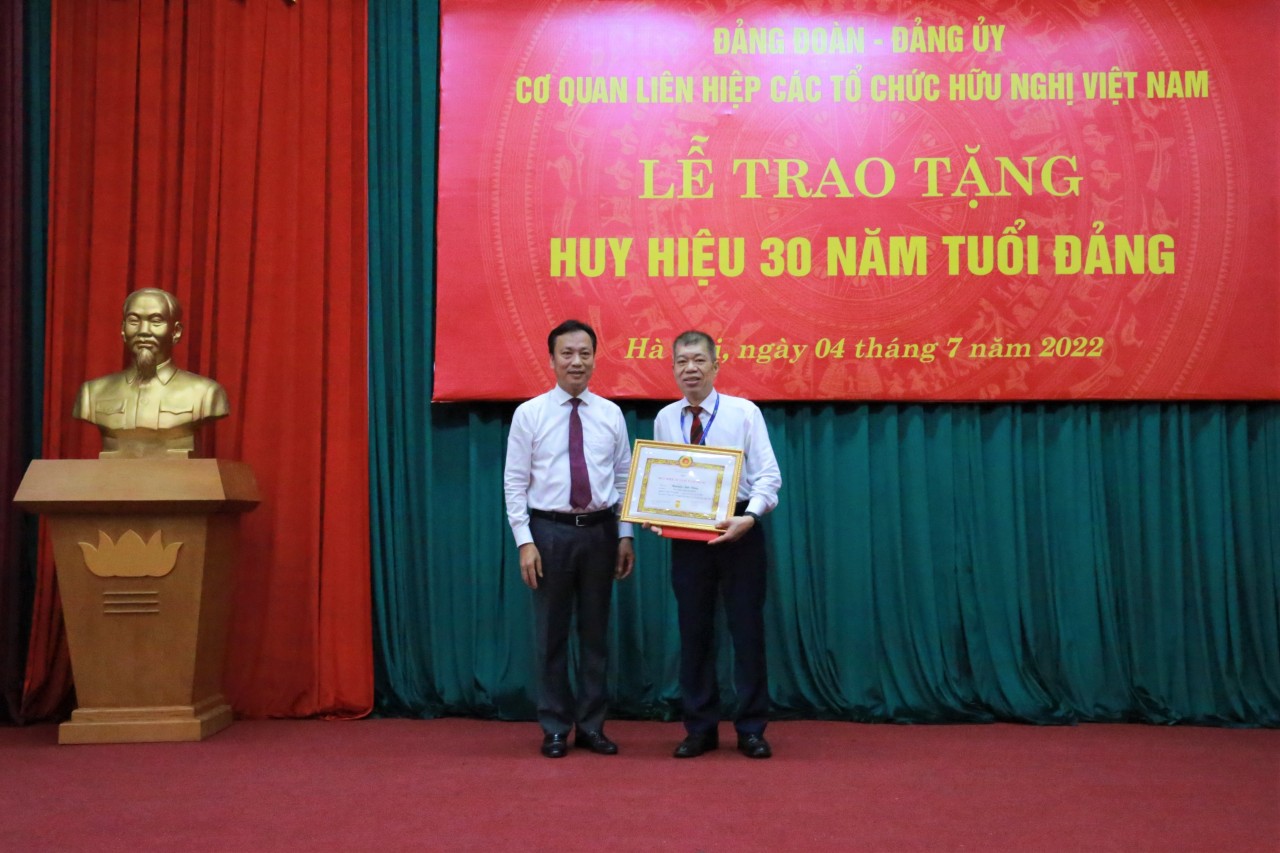 Ông Lại Xuân Lâm - Phó Bí thư Đảng ủy khối các cơ quan Trung ương trao huy hiệu 30 năm tuổi Đảng cho ông Nguyễn Anh Dũng - Phó trưởng ban phụ trách Ban Công tác địa phương.