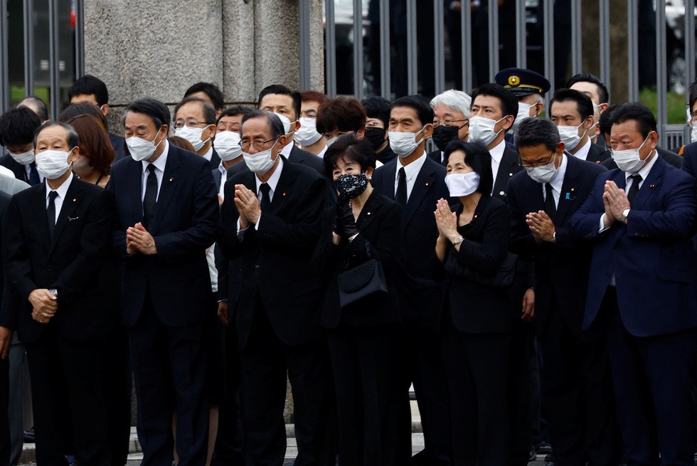 Các nghị sĩ Nhật Bản cầu nguyện khi chiếc xe chở linh cữu của cố Thủ tướng Nhật Bản Abe Shinzo đến phía trước tòa nhà Quốc hội Nhật Bản sau tang lễ tại đền Zojoji ở Tokyo, Nhật Bản ngày 12-7 - Ảnh: REUTERS