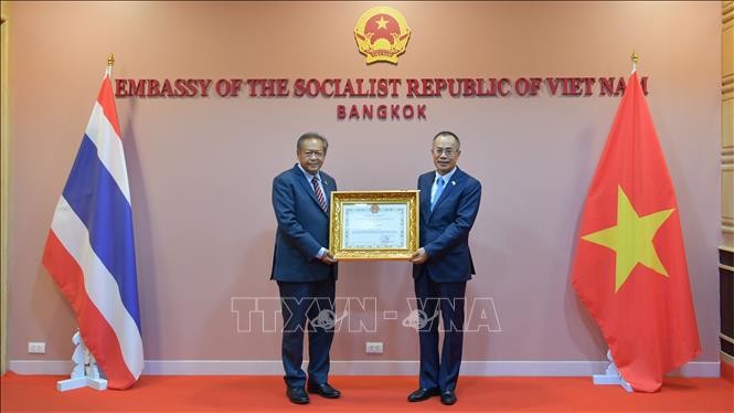Đại sứ Việt Nam tại Thái Lan Phan Chí Thành (bên phải) trao tặng giấy khen cho ông Adisak Thepart (bên trái), nguyên Tỉnh trưởng tỉnh Nakhon Phanom (Ảnh: Huy Tiến/Pv TTXVN tại Thái Lan).