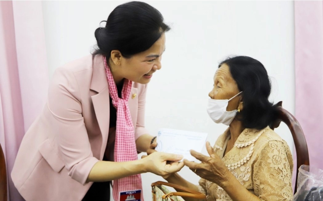 Chủ tịch Hội LHPN Việt Nam Hà Thị Nga (trái) trao quà cho một phụ nữ Campuchia từng tham gia hỗ trợ quân tình nguyện Việt Nam.
