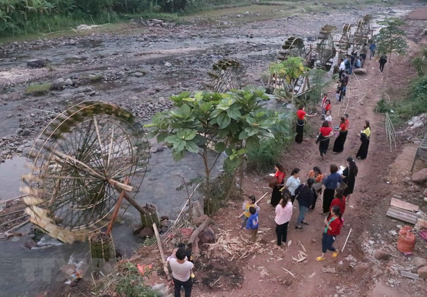 Du khách tham quan hệ thống những cọn nước trên suốt chiều dài hàng chục mét bên suối Nậm Bai chảy quanh bản Nà Sự (Ảnh: Xuân Tiến/TTXVN).