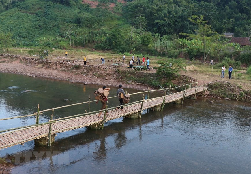 Cây cầu tre bắc qua suối Nậm Bai là con đường dẫn sang bãi đất trống, nơi diễn ra các chương trình gia lưu văn hóa, văn nghệ và thưởng thức ẩm thực ngoài trời khi du khách đến bản Nà Sự (Ảnh: Xuân Tiến/TTXVN).