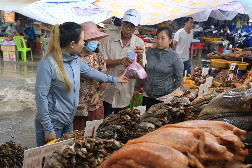 Theo chị Thùy Dương (27 tuổi, bìa phải), khách phương xa đến chợ Châu Đốc sau khi đi tham quan, du lịch, cúng Bà. Họ tiện đường mua ít mắm về làm quà cho người thân, người quen. Lượng khách đông nhất là từ rằm tháng giêng đến hết vía bà.