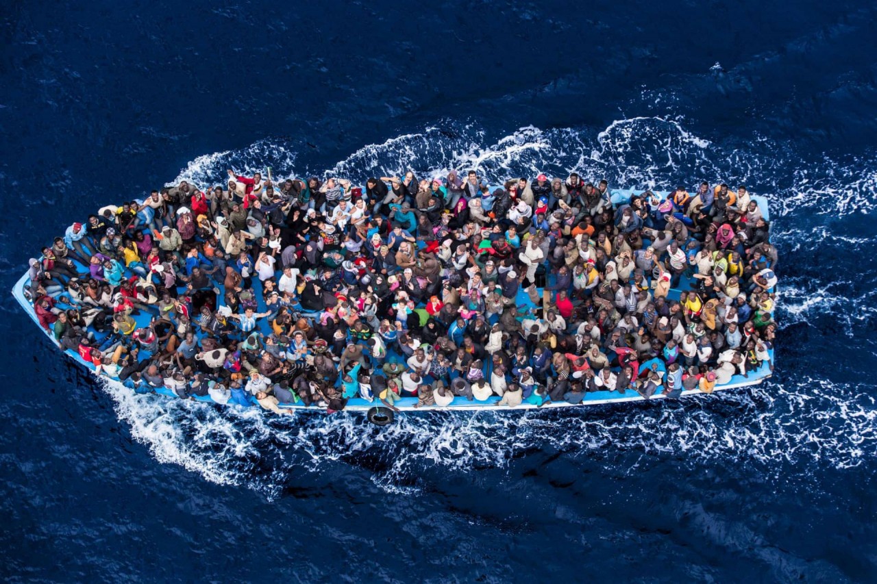 Người di cư chờ đợi được giải cứu khỏi chiếc thuyền quá tải của họ được chụp từ một máy bay trực thăng của hải quân Italy (Ảnh: Eyevine).