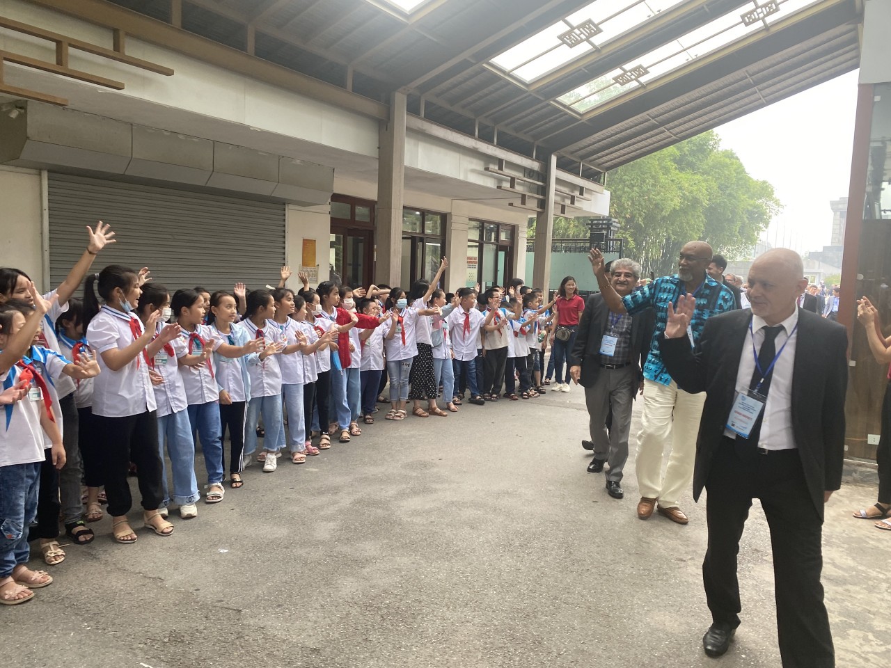 Các đại biểu vui mừng gặp các cháu học sinh khi tham quan Khu di tích Chủ tịch Hồ Chí Minh tại Phủ Chủ tịch (Ảnh: Huyền Nhung).