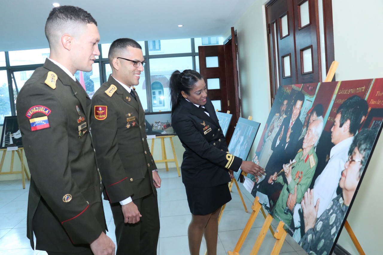 Các khách mời chiêm ngưỡng bức ảnh Tổng thống Hugo Chavez tặng bản sao thanh kiếm của Anh hùng Simon Bolivar 