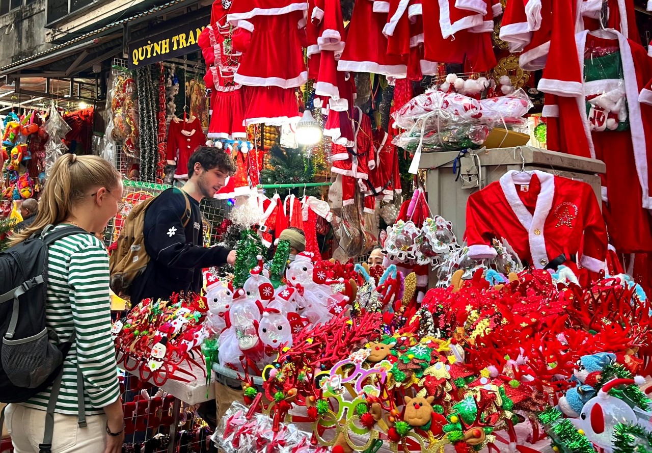 Lise (trái) và Bastien sinh viên trao đổi người Pháp đang cùng nhau dạo phố Hàng Mã và chọn đồ trang trí Giáng Sinh (Ảnh: Thời Đại)