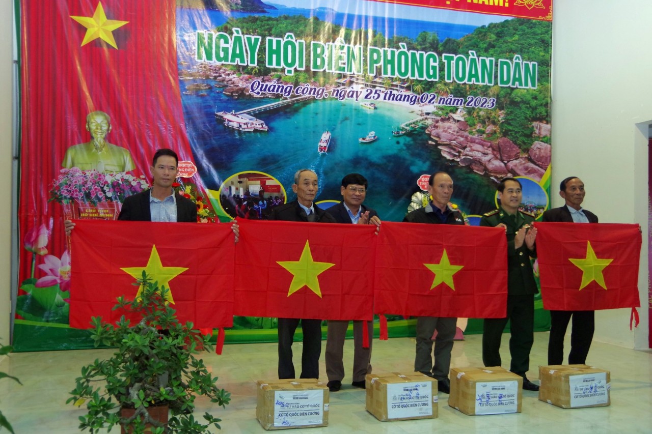 Đại diện Bộ chỉ huy BĐBP tỉnh và UBMTTQVN tỉnh Thừa Thiên Huế tặng cờ Tổ quốc cho người dân. (Ảnh: Võ Tiến)
