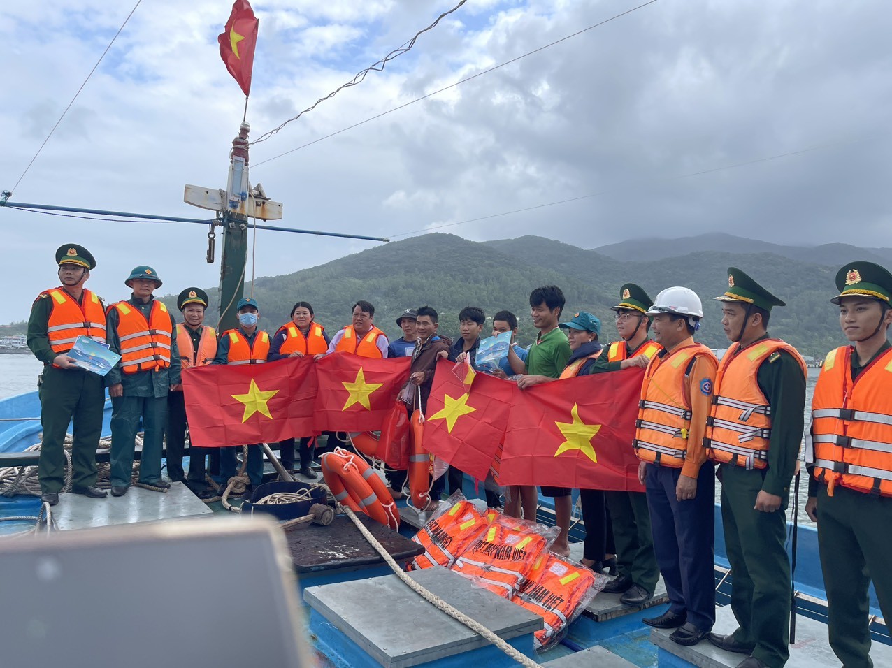Ban Chỉ huy Biên phòng cửa khẩu cảng Đà Nẵng phối hợp với các đơn vị tặng cờ Tổ quốc và phao cứu sinh cho ngư dân trên vịnh Mân Quang. Ảnh: Hồng Quang.