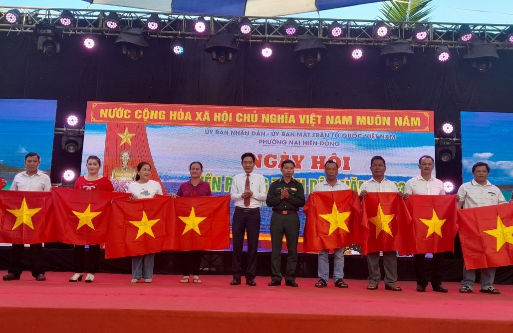 Đại diện lãnh đạo Đồn Biên phòng Sơn Trà và Đảng ủy phường Nại Hiên Đông trao tặng cờ Tổ quốc cho ngư dân. Ảnh: TRúc Hà.
