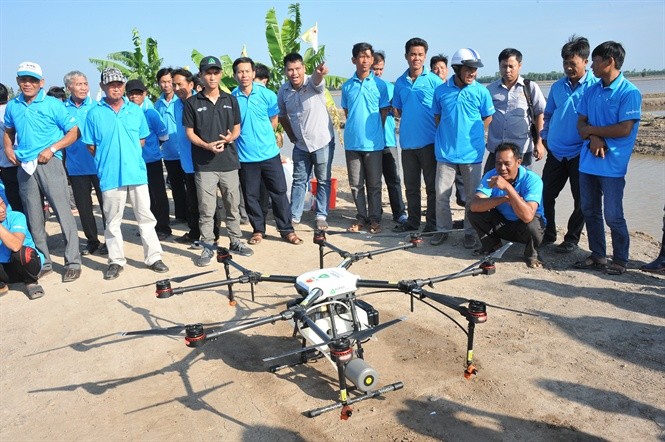 nông dân ở các tỉnh ĐBSCL đến tham quan máy bay không người lái phun thuốc BVTV trên đồng lúa tại Long An (Ảnh: Tập đoàn Lộc Trời).