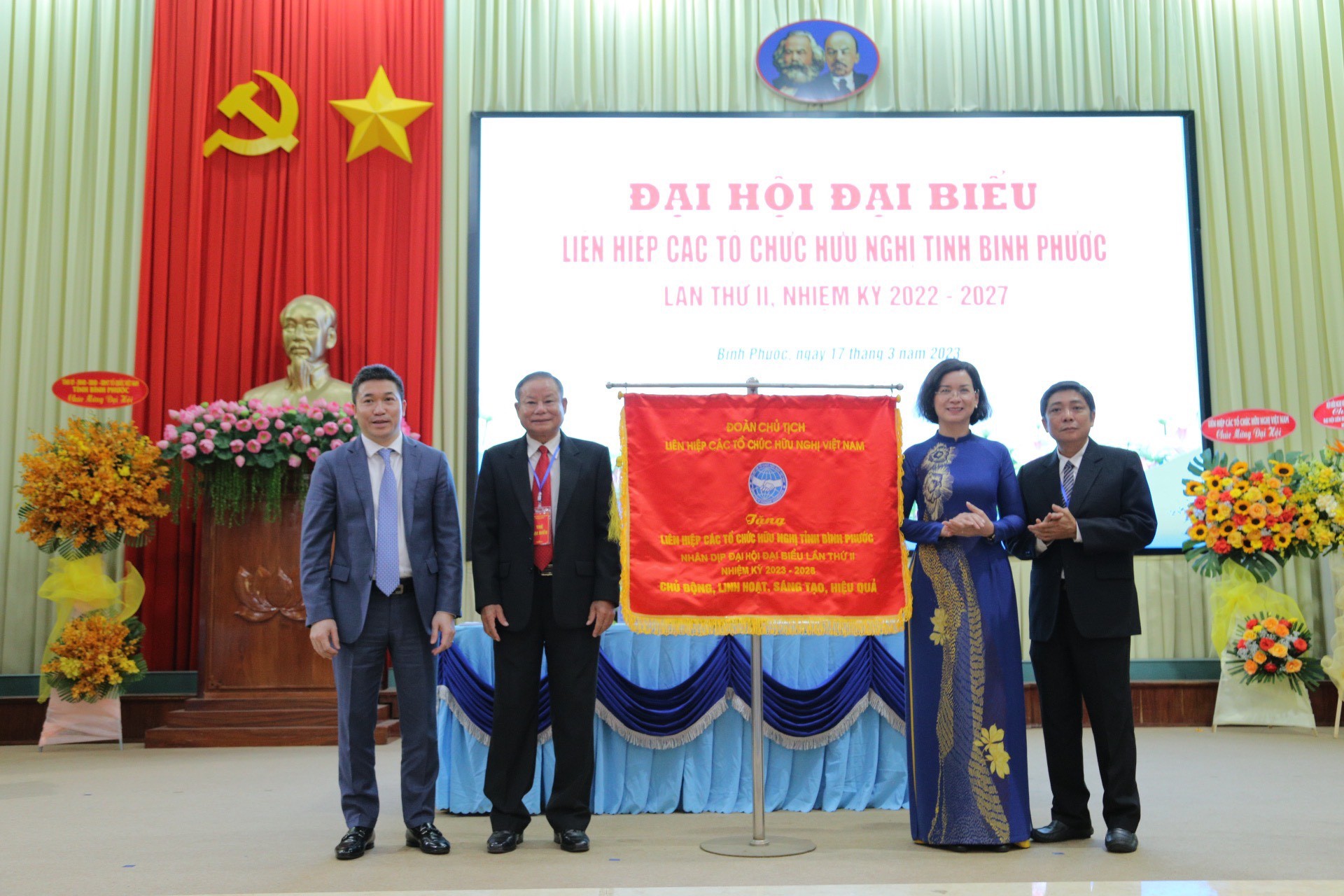 Ông Phan Anh Sơn, Phó Chủ tịch, Tổng Thư ký Liên hiệp các tổ chức hữu nghị Việt Nam (ngoài cùng, bên trái) tặng Cờ lưu niệm cho Liên hiệp các tổ chức hữu nghị tỉnh Bình Phước nhân dịp Đại hội Đại biểu lần thứ II.