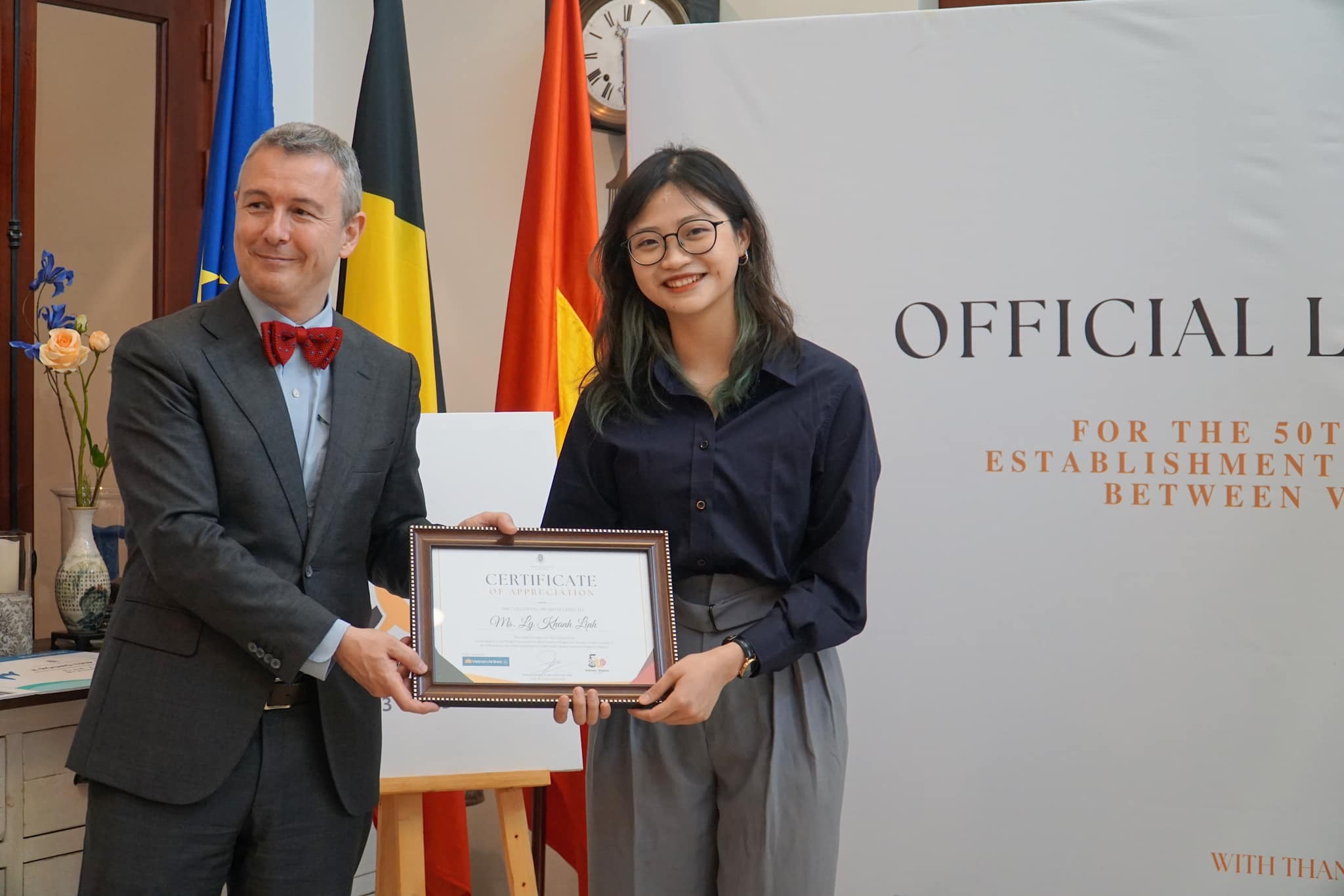 Đại sứ Karl Van den Bossche trao chứng nhận chiến thắng cuộc thi thiết kế logo cho tác giả Lý Khánh Linh (Ảnh: ĐSQ Bỉ tại Việt Nam).