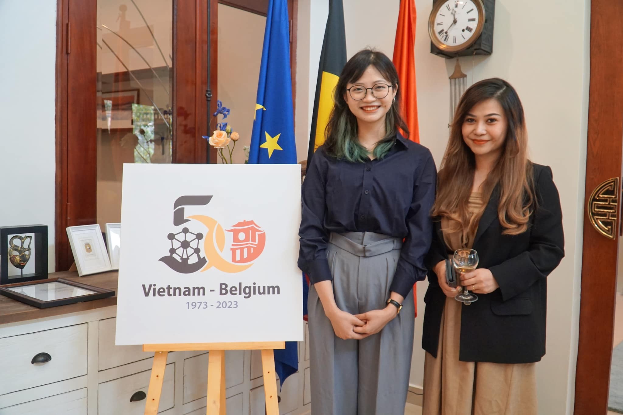 Tác giả Lý Khánh Linh (thứ hai, từ phải sang) bên logo chính thức kỷ niệm 50 năm quan hệ ngoại giao Việt Nam-Bỉ (Ảnh: ĐSQ Bỉ tại Việt Nam).