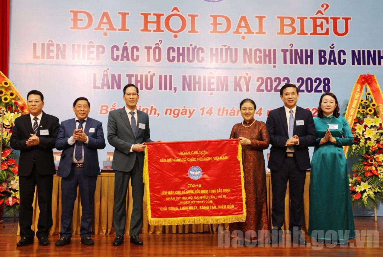 Chủ tịch Liên hiệp các tổ chức Hữu nghị Việt Nam Nguyễn Phương Nga tặng Cờ lưu niệm với dòng chữ “Chủ động, linh hoạt, sáng tạo, hiệu quả”.