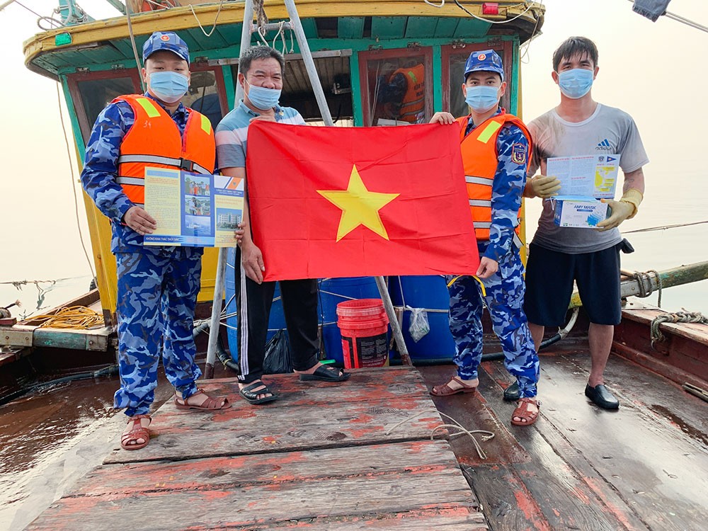 Tàu CSB 3004 tặng cờ Tổ quốc, khẩu trang y tế và phát tờ rơi tuyên truyền pháp luật cho ngư dân.