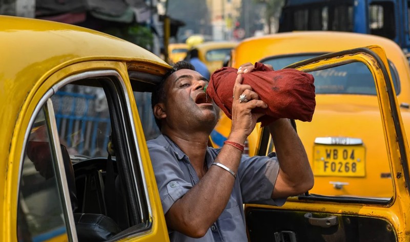 Một tài xế taxi uống nước từ chai trong cái nóng buổi trưa ở Kolkata, Ấn Độ, vào ngày 18/4 (Ảnh: Getty).