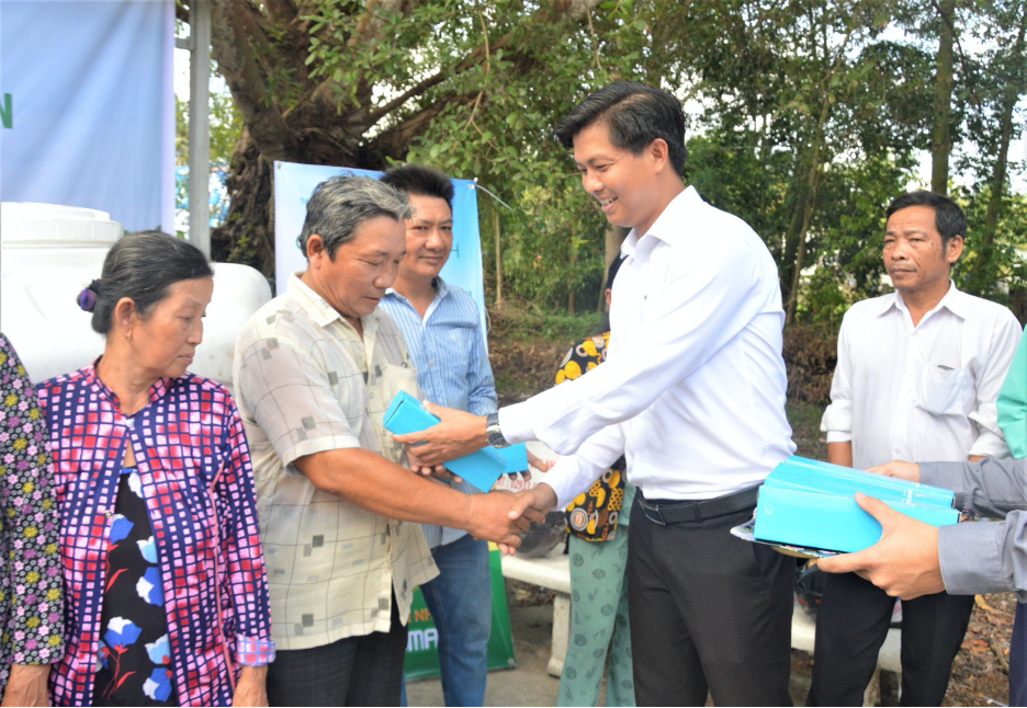 Đại diện Tập đoàn Tân Á Đại Thành trao tặng bình giữ nhiệt cho người dân.
