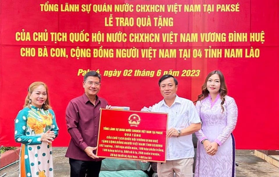 Đại diện Tổng Lãnh sự quán Việt Nam tại Pakse trao quà của Chủ tịch Quốc hội cho đại diện cộng đồng người Việt tại tỉnh Sekong.
