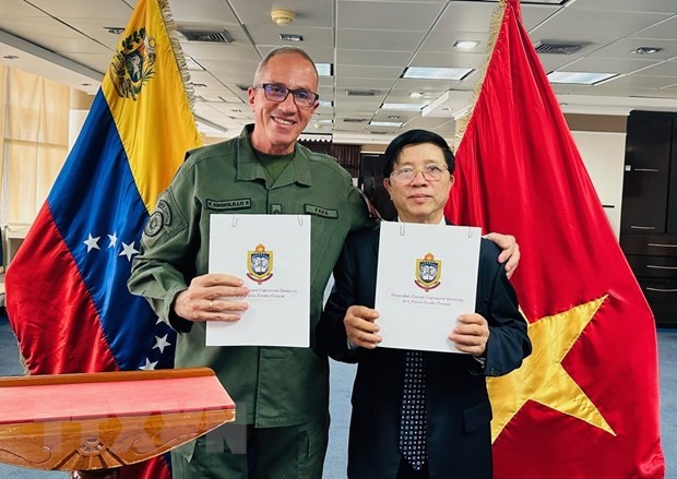 Thượng tướng, Hiệu trưởng UNEFA Pascualino Angiolillo và Hiệu trưởng UTM Nguyễn Xuân Sơn ký Ý định thư hợp tác giữa hai trường. (Ảnh: TTXVN/phát)