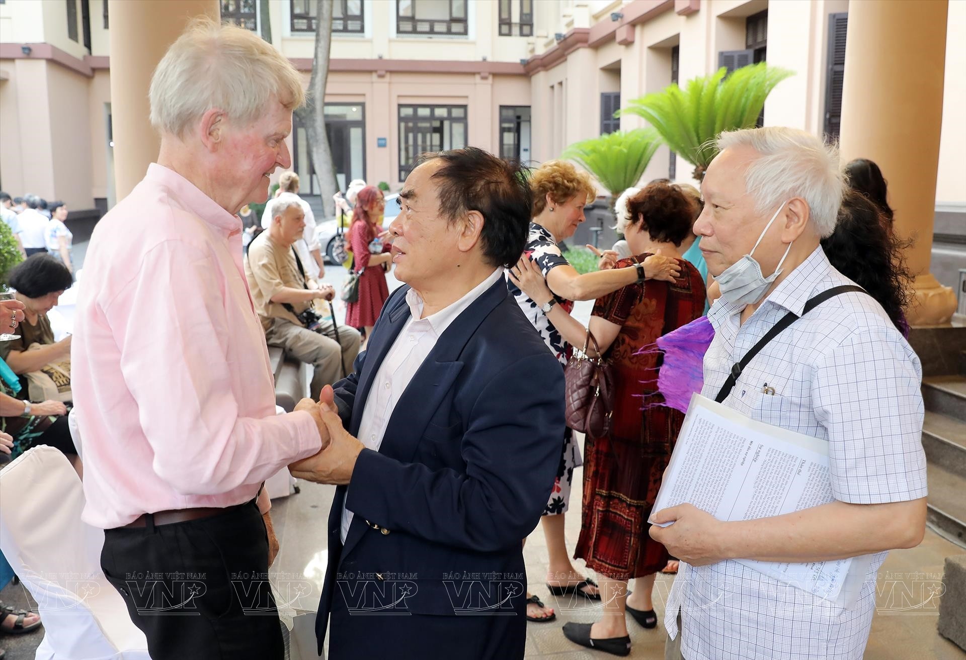 Họa sĩ David Thomas (bìa trái) gặp lại những người bạn Việt Nam tại triển lãm hồi tháng 4/2023 (Ảnh: TTXVN).
