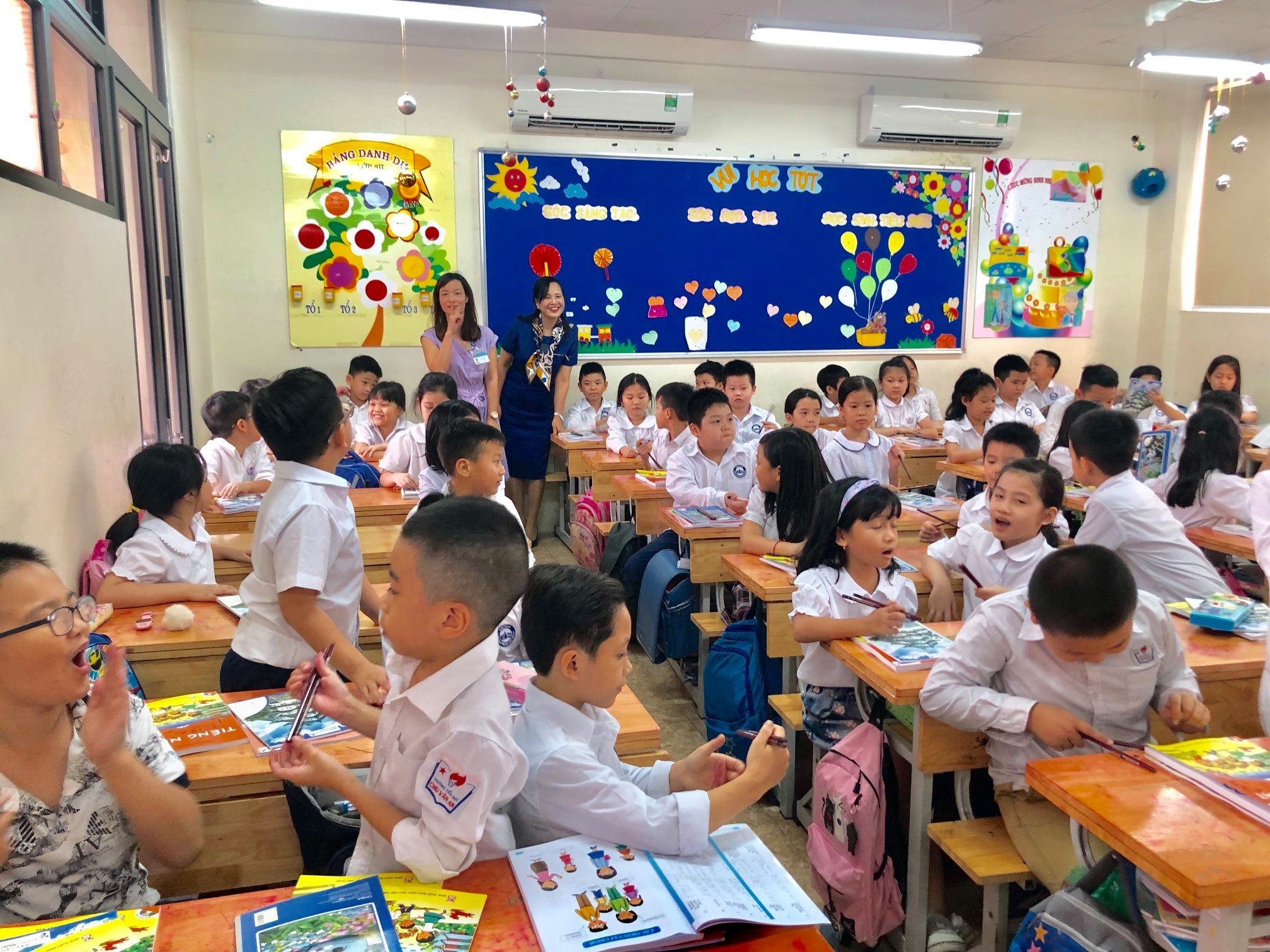 Chị Ngô Minh Thủy (váy xanh) trong một lần cùng Đại sứ quán Nhật, Quỹ Japan Foundation đến tặng sách, đồ dùng học tập và dự giờ tiếng Nhật của học sinh lớp 3 Trường Tiểu học Chu Văn An - Hà Nội vào năm 2019 (Ảnh: NVCC).