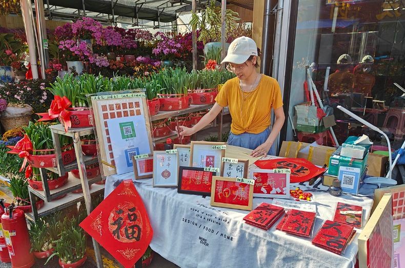 Chị Li Bingqian bán đồ trang trí bằng chữ viết tay của mình trong một hội chợ hoa ở Thâm Quyến, tỉnh Quảng Đông, ngày 14 tháng 1 năm 2023. Ảnh của Li