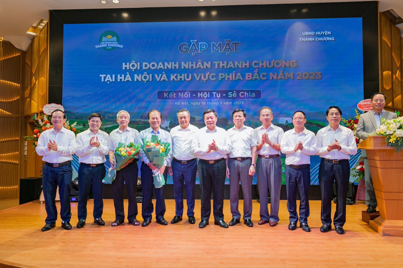 Ông Nguyễn Xuân Thắng và ông Trần Sỹ Thanh cùng lãnh đạo huyện Thanh Chương tặng hoa chúc mừng Ban chấp hành mới của Hội Doanh nhân Thanh Chương tại Hà Nội.