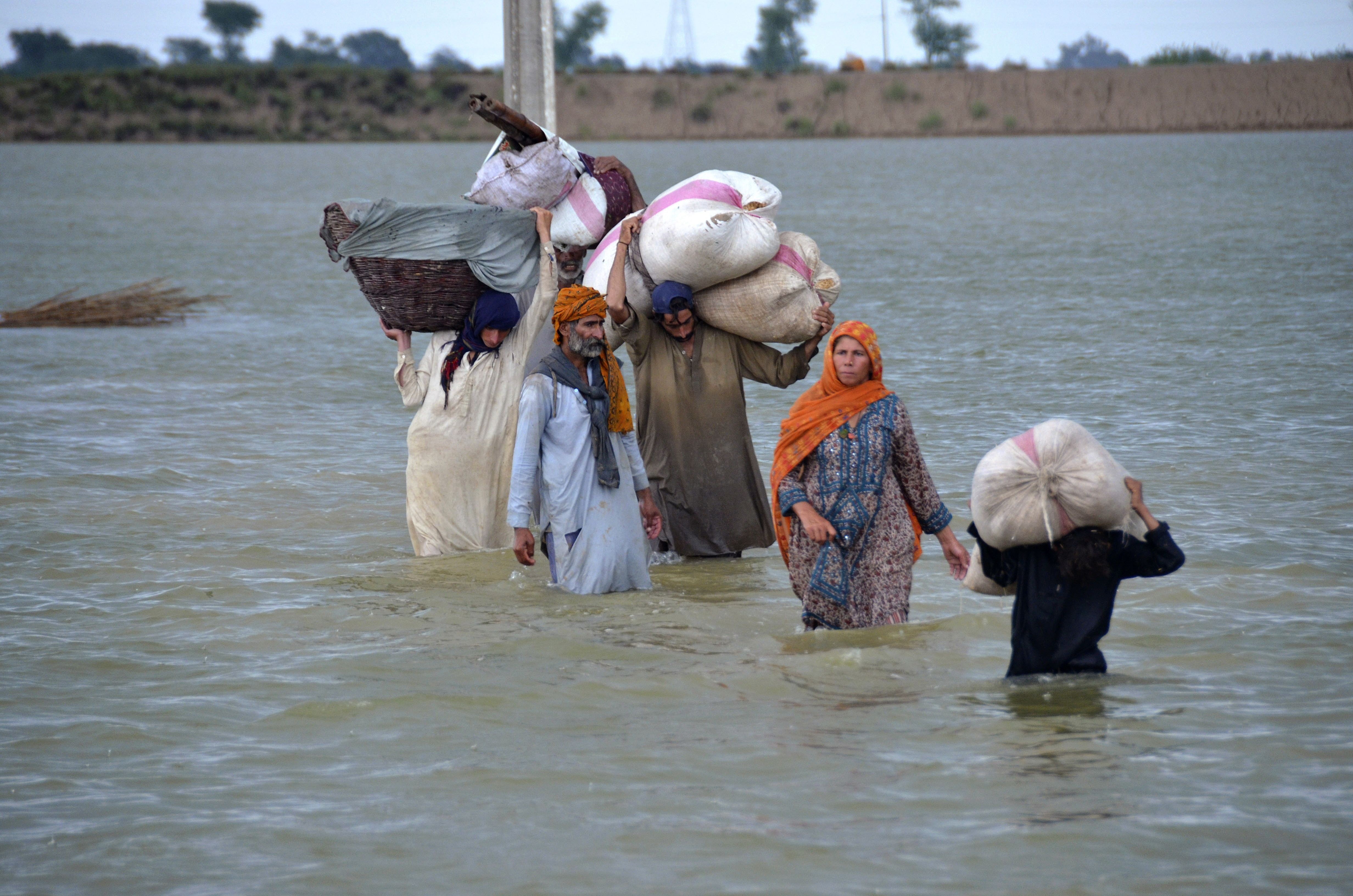 Một gia đình phải sơ tán lội qua khu vực ngập lụt ở Jaffarabad, một huyện thuộc tỉnh Baluchistan phía tây nam Pakistan, vào ngày 24/8