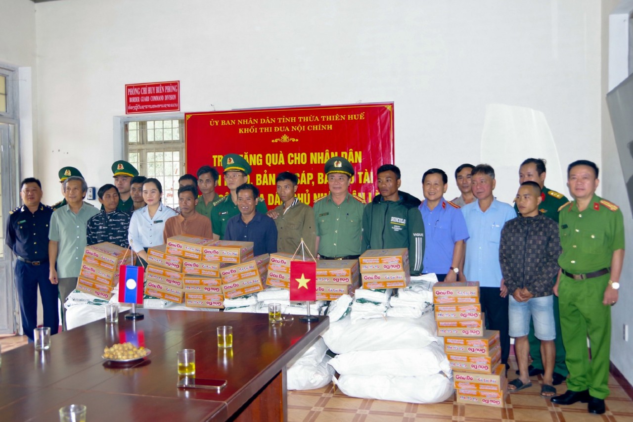 Đại diện các đơn vị tặng quà cho nhân dân bản Cô Tài, huyện Xá Muội, tỉnh Salavan, Lào. Ảnh: Võ Tiến.