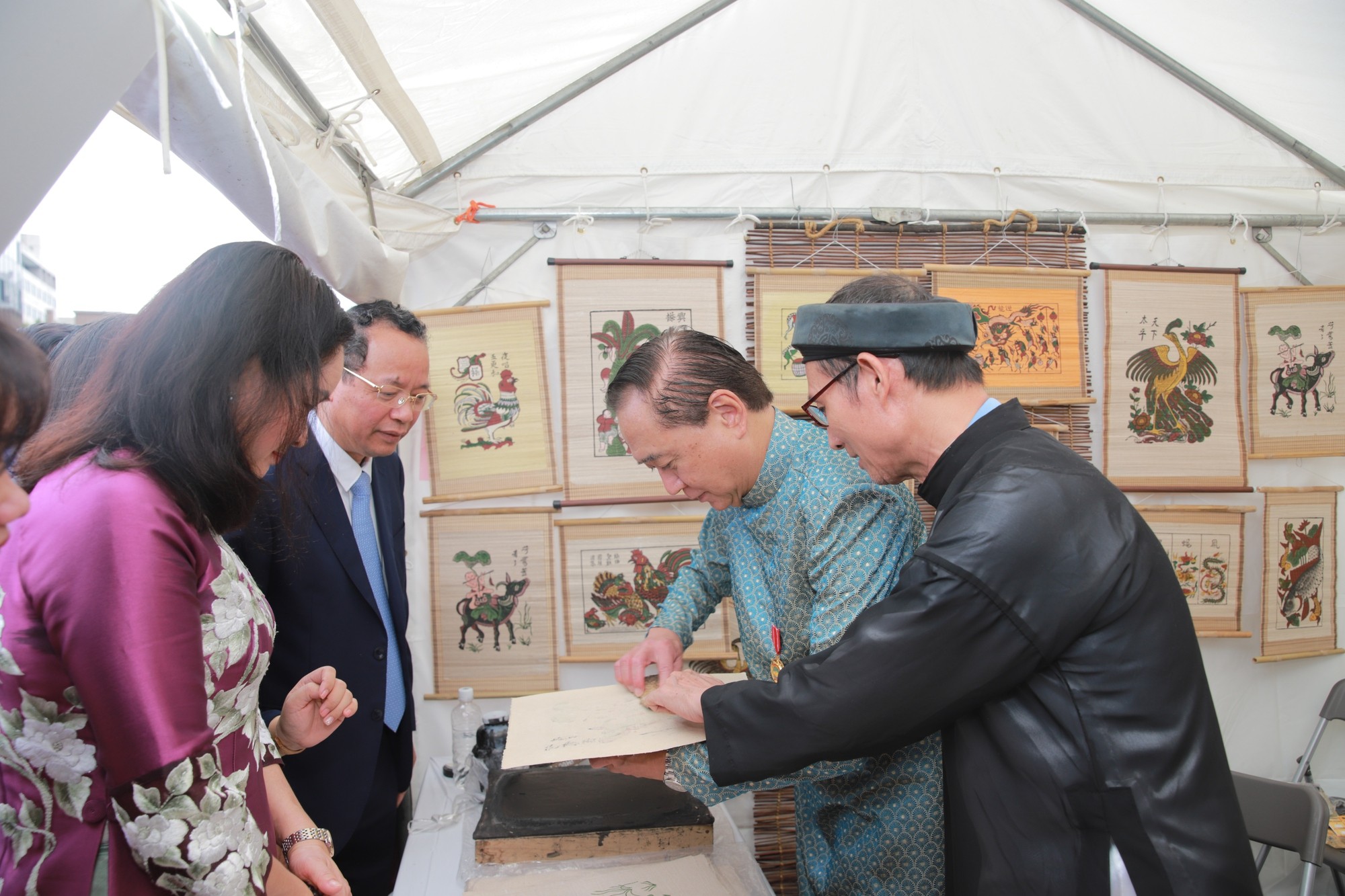 Thống đốc tỉnh Kanagawa thích thú với trải nghiệm vẽ tranh dân gian Đông Hồ. (Ảnh: Toquoc.vn)