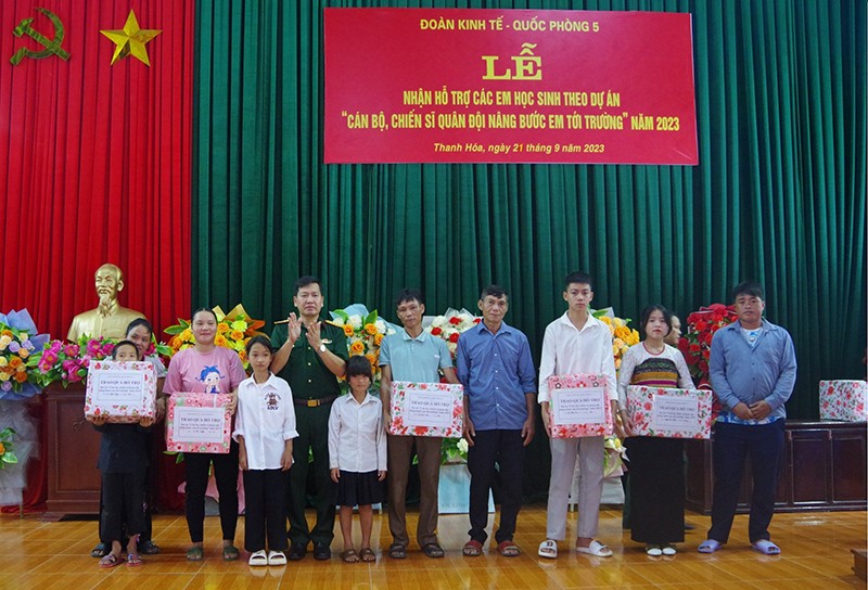 Đại tá Mai Văn Tài, Chính uỷ Đoàn KTQP 5 trao quà hỗ trợ cho các em học sinh thuộc diện thụ hưởng dự án đạt kết quả cao trong năm học 2022 - 2023.