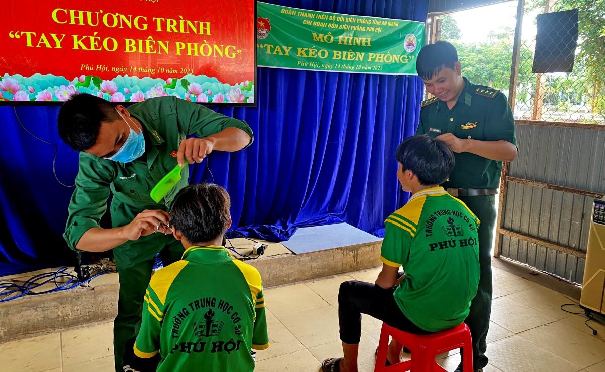 Cán bộ, chiến sĩ Đồn Biên phòng Phú Hội cắt tóc miễn phí cho các em học sinh. Ảnh: Chiến Khu