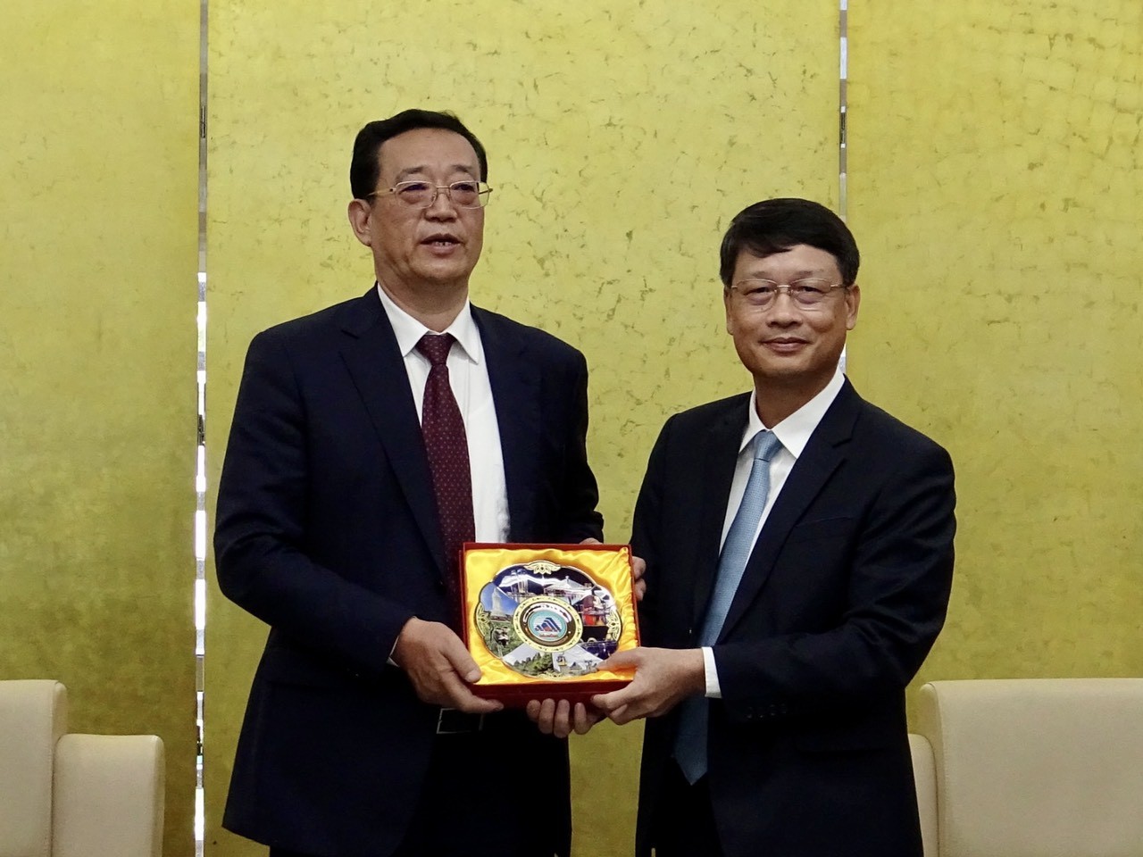 Chủ tịch Ủy ban MTTQ Việt Nam thành phố Ngô Xuân Thắng (bên phải) tặng quà lưu niệm đến Phó Chủ tịch Hội nghị Hiệp thương Chính trị Nhân dân tỉnh Liêu Ninh (Trung Quốc) Vương Minh Ngọc. (Ảnh: dạng.gov)