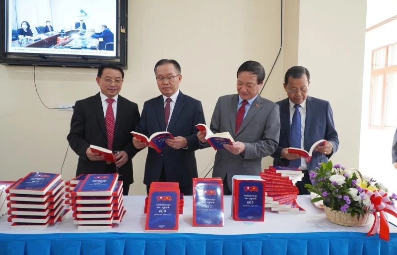 Các đại biểu tham quan khu trưng bày cuốn sách “60 năm quan hệ ngoại giao Lào-Việt Nam”. (Ảnh: Nhân Dân)