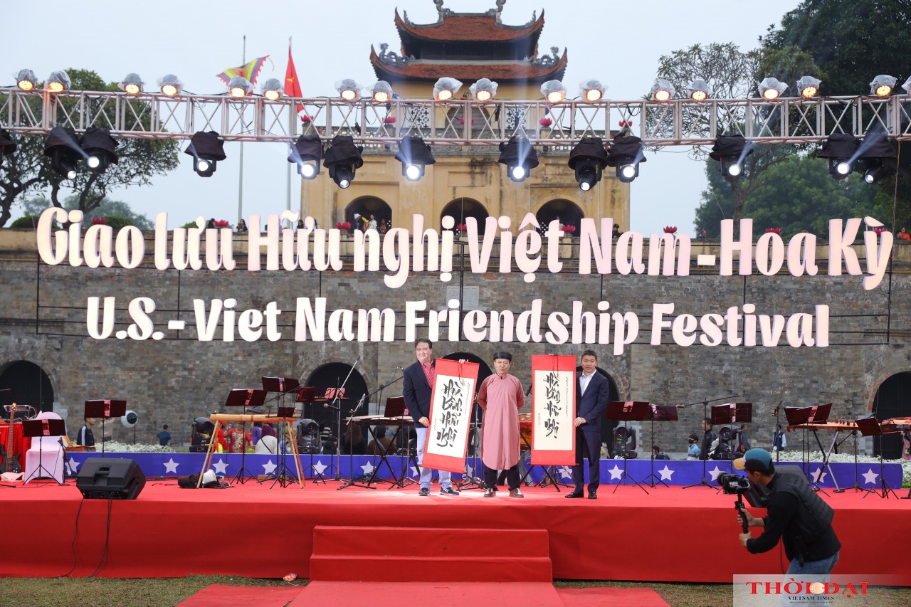 Nghệ nhân Kiều Quốc Khánh tặng tranh thư pháp cho Chủ tịch VUFO Phan Anh Sơn (phải) và Đại sứ Hoa Kỳ tại Việt Nam Marc E.Knapper tại chương trình.