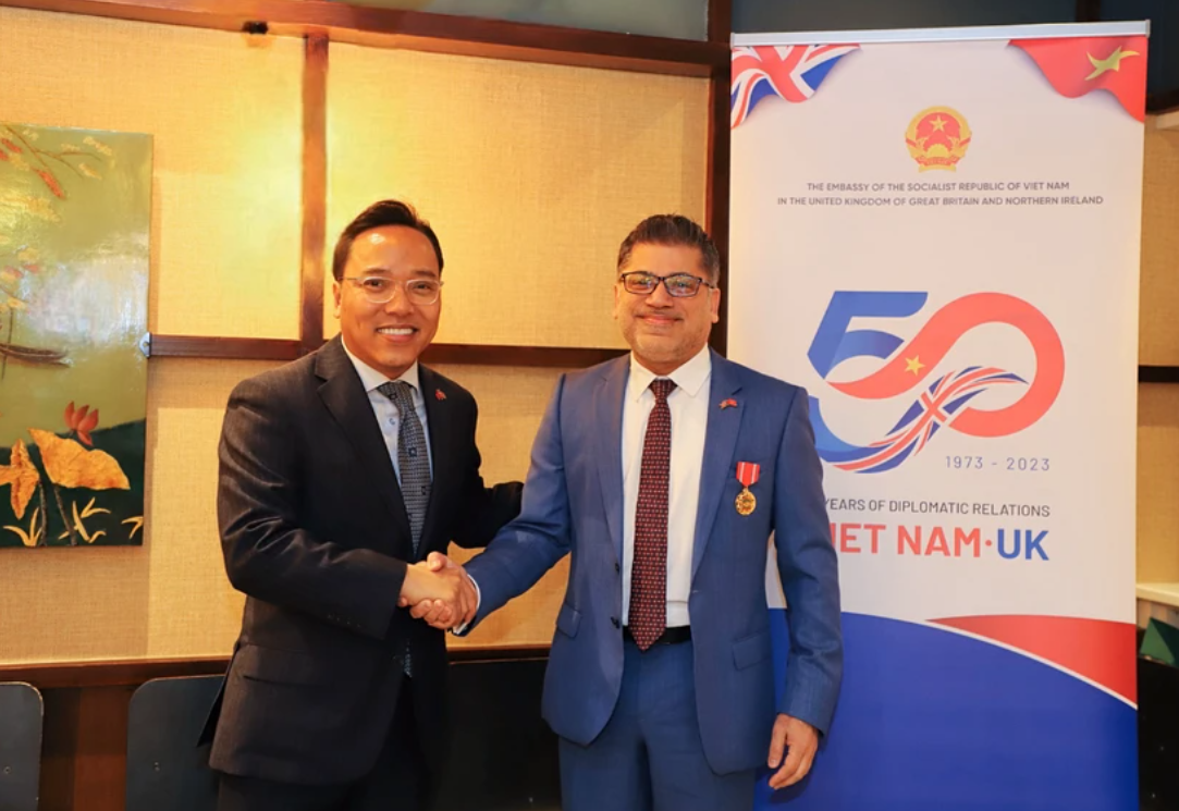 Đại sứ Việt Nam tại Vương quốc Anh Nguyễn Hoàng Long công bố và trao cho Chủ tịch kiêm Tổng Giám đốc AstraZeneca Việt Nam tại Anh. 