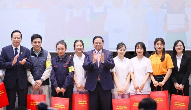 Thủ tướng Phạm Minh Chính tặng quà đại diện người lao động và thực tập sinh Việt Nam tham dự diễn đàn.