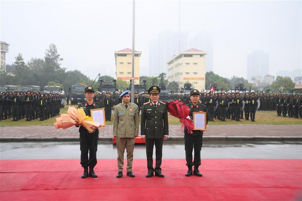 Thứ trưởng Lương Tam Quang trao Quyết định thành lập Đơn vị Cảnh sát gìn giữ hòa bình số 1 và ngài Faisal Shahkar, Tư lệnh Cảnh sát Liên hợp quốc tặng hoa chúc mừng. (Ảnh: Bộ Công an)