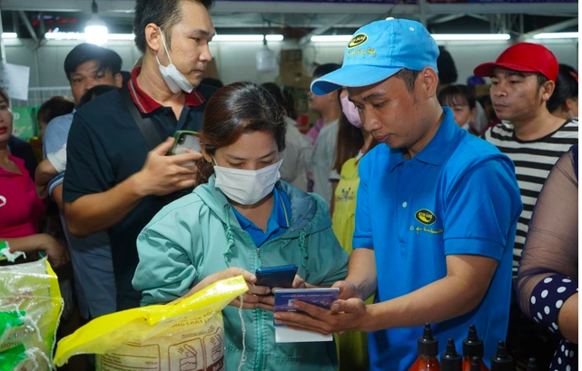 Công nhân quét mã thanh toán tại “Ngày hội CN - Phiên chợ nghĩa tình” do LĐLĐ TP HCM tổ chức tại quận Bình Tân (Ảnh: NLD).