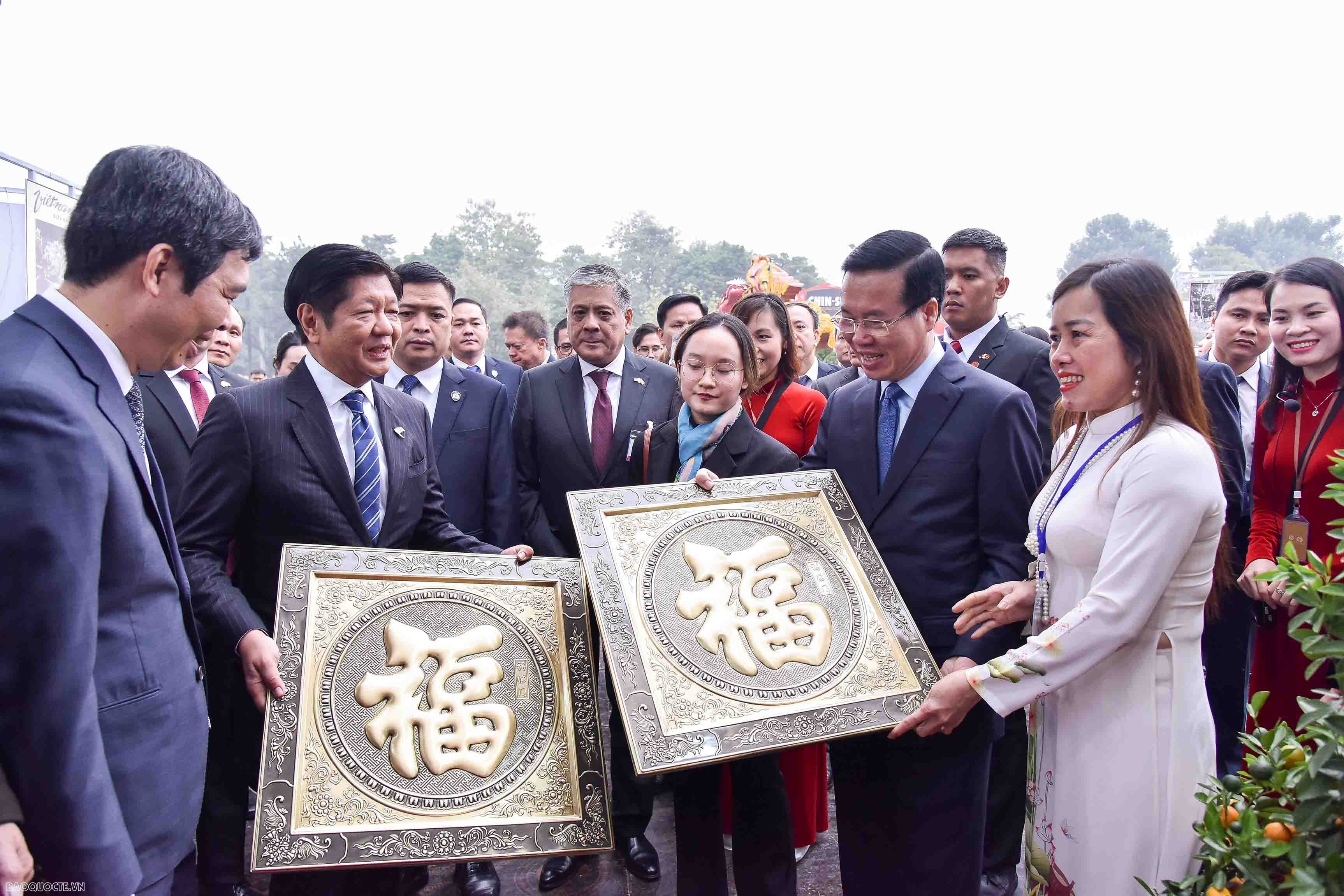 Phu nhân Chủ tịch nước Phan Thị Thanh Tâm giới thiệu tới Phu nhân Louise Araneta - Marcos về ý nghĩa của hoa đào đối với ngày Tết truyền thống của Việt Nam. Bà tặng Phu nhân Louise Araneta - Marcos một cành đào nhỏ, bà Louise Araneta - Marcos tỏ ra rất thích món quà ý nghĩa này. (Ảnh: Báo Thế giới & Việt Nam)