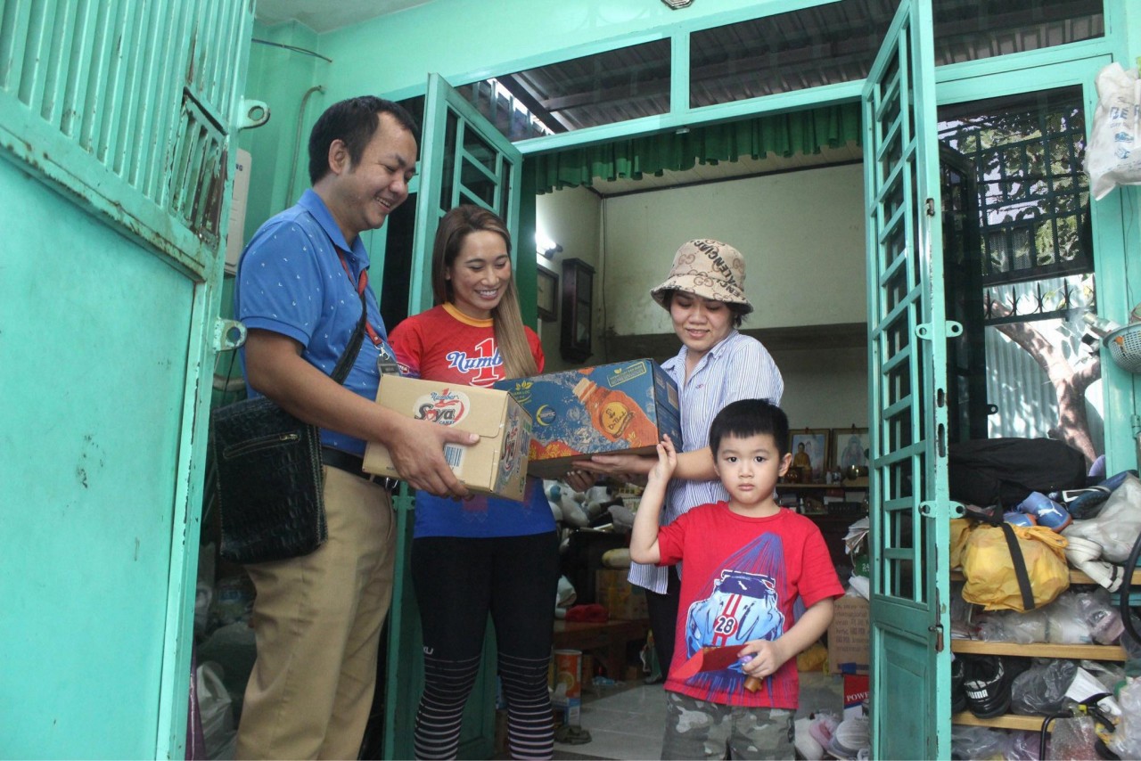 Đại diện Công ty Tân Hiệp Phát trao quà và bao thư lì xì cho chị Chi và bé Hải tại quận Gò Vấp, TP.HCM.