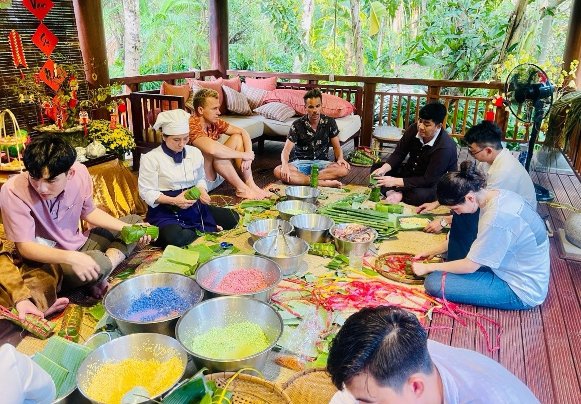Du khách nước ngoài được trải nghiệm cách gói bánh chưng tại một khách sạn ở Phú Quốc.