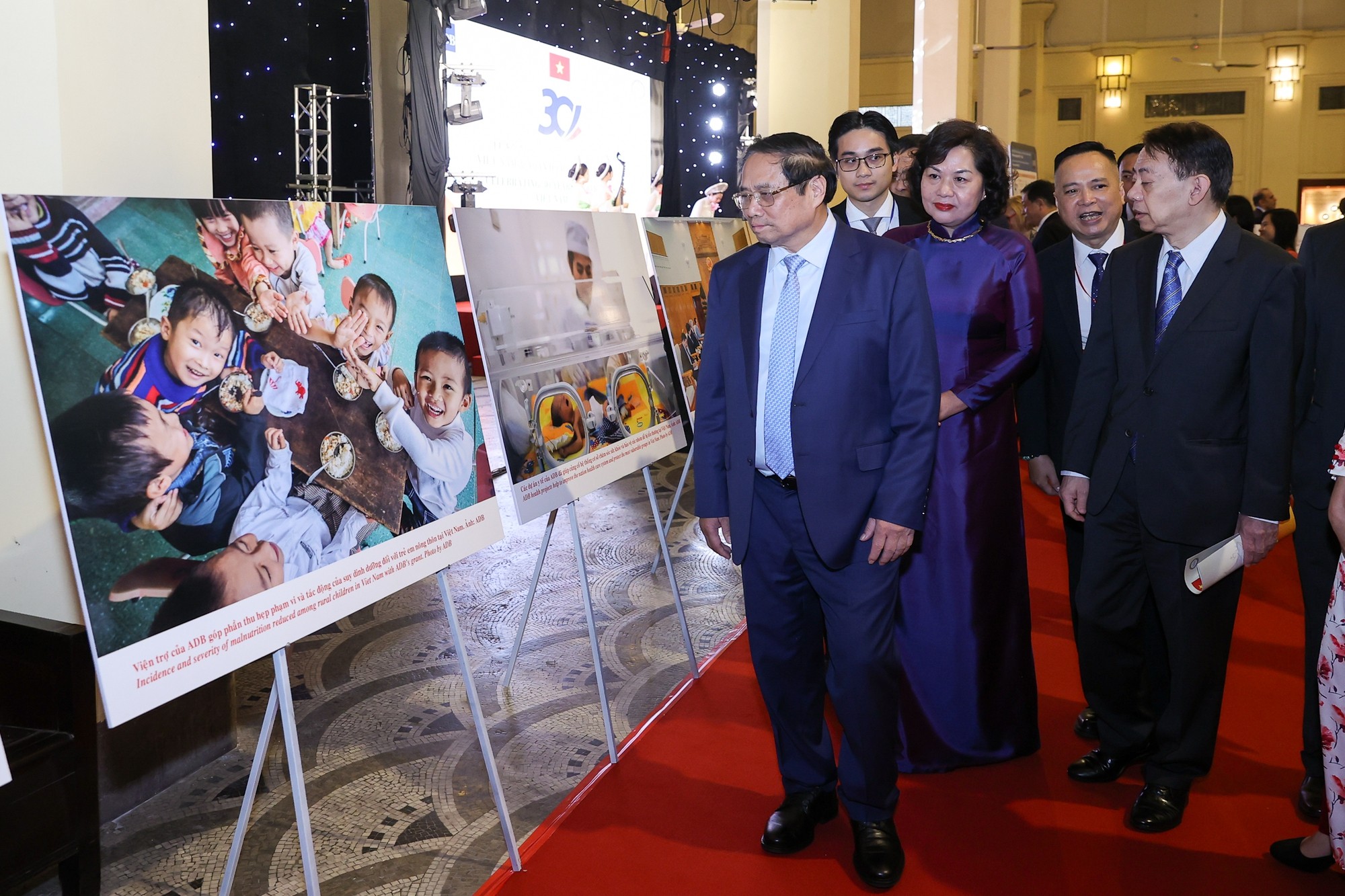 Thủ tướng Phạm Minh Chính và Chủ tịch ADB Masatsugu Asakawa tham quan khu trưng bày các hoạt động, dự án của Việt Nam từ nguồn vốn vay của ADB. (Ảnh: VGP/Nhật Bắc)