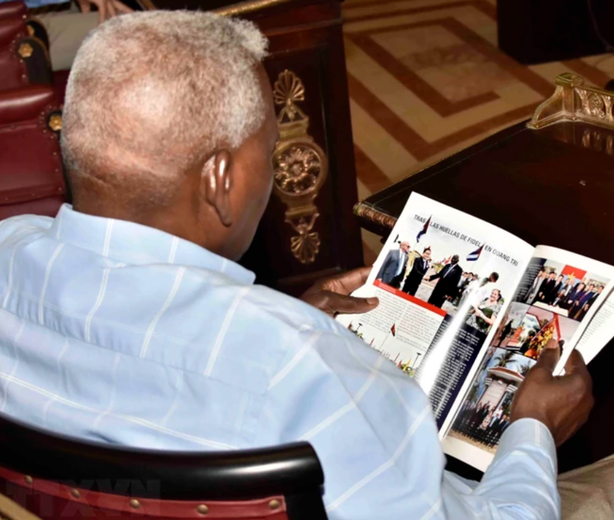 Chủ tịch Quốc hội Cuba Esteban Lazo Hernández đọc Tạp chí Quốc hội đặc biệt 'Cuba và Việt Nam: biểu tượng của tình anh em.' (Ảnh: Mai Phương/TTXVN)