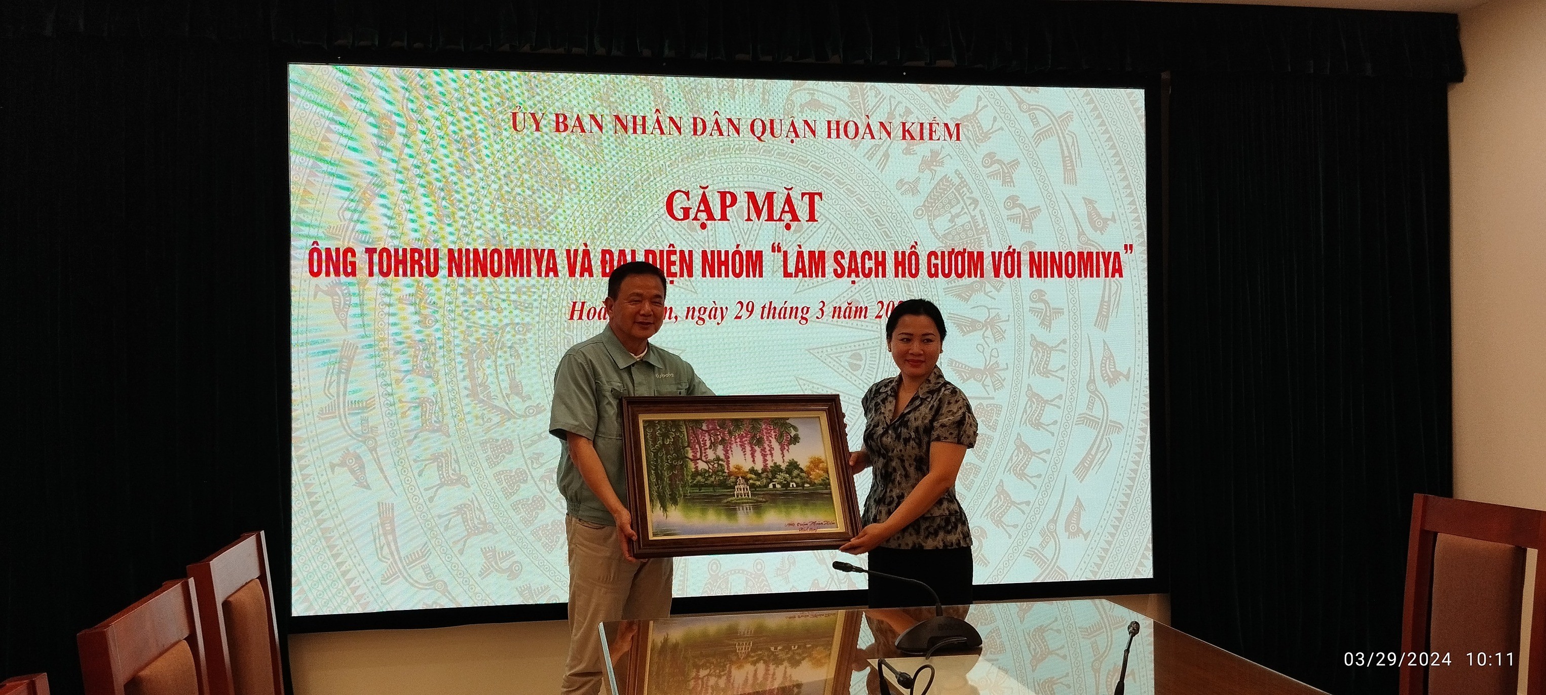 Phó Chủ tịch UBND quận Hoàn Kiếm Lê Anh Thư tặng quà lưu niệm cho ông Ninomiya. (Ảnh: FB Phuong Nguyen)