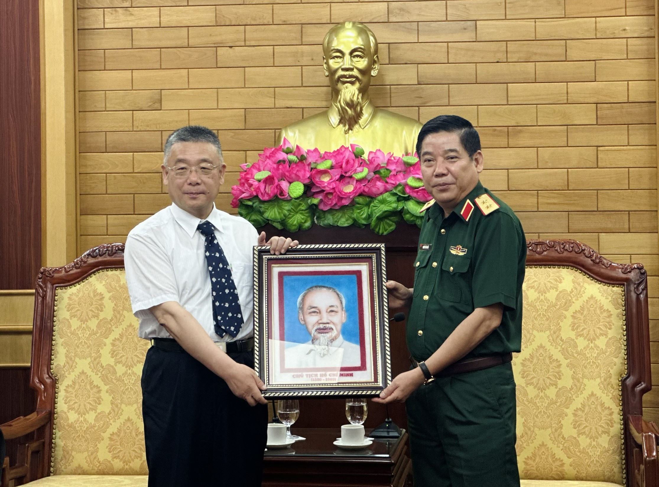 Trung tướng Nguyễn Văn Gấu trao bức ảnh Chủ tịch Hồ Chí Minh tặng ông Vi Tiêu Nghị. 