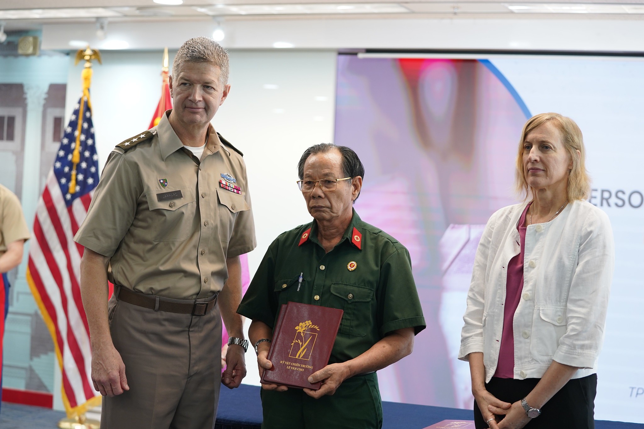 Ông Trần Văn Bản nhận kỷ vật của các đồng đội từ Trung tướng Mỹ James Jarrard ngày 24-5