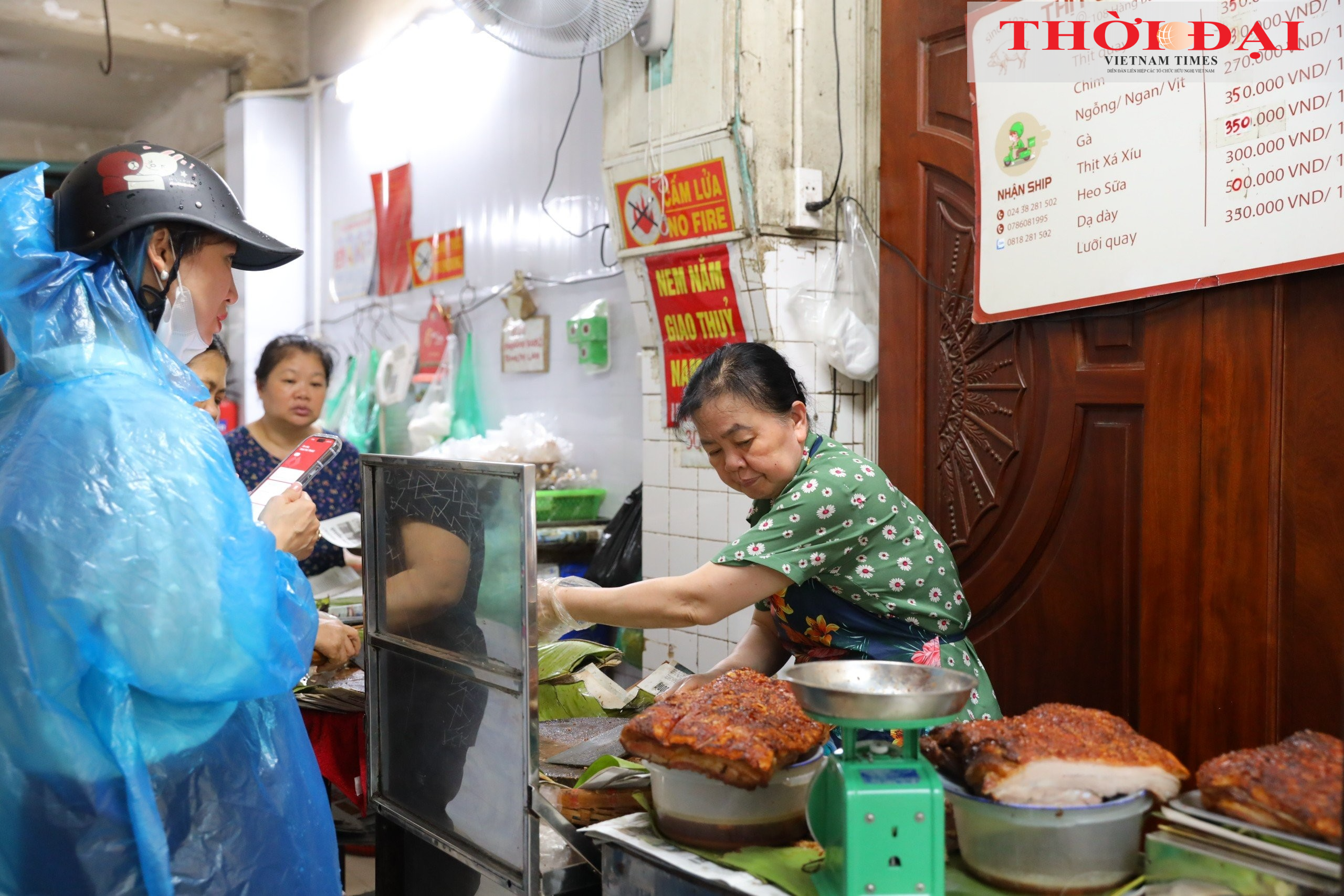 Bà Trang Thị Thủy, chủ cửa hàng thịt quay Vạn Thành chặt thịt cho khách. (Ảnh: Đinh Hòa)