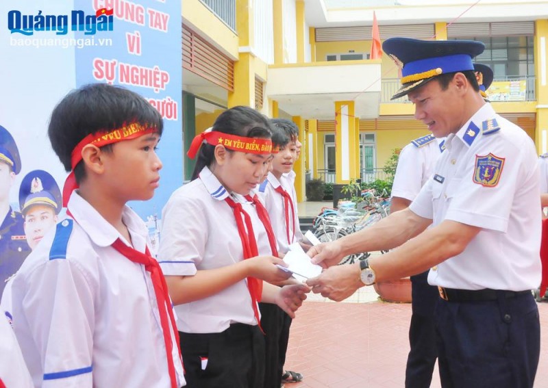 Đại tá Phạm Hồng Quế - Phó Chính ủy Bộ Tư lệnh Vùng CSB 2 tặng học bổng cho học sinh.